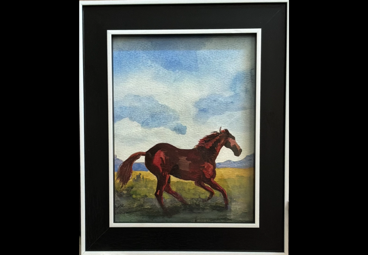 A framed painting of a brown horse running through a grassy field under a blue sky, set in a black frame with a white mat.